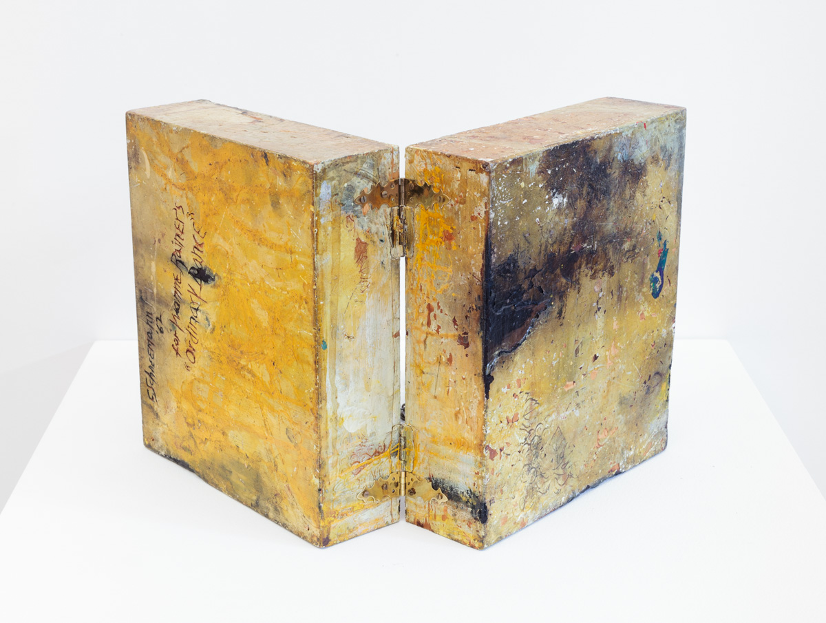 back of the work: an open wooden box, mostly yellow, with some black patches