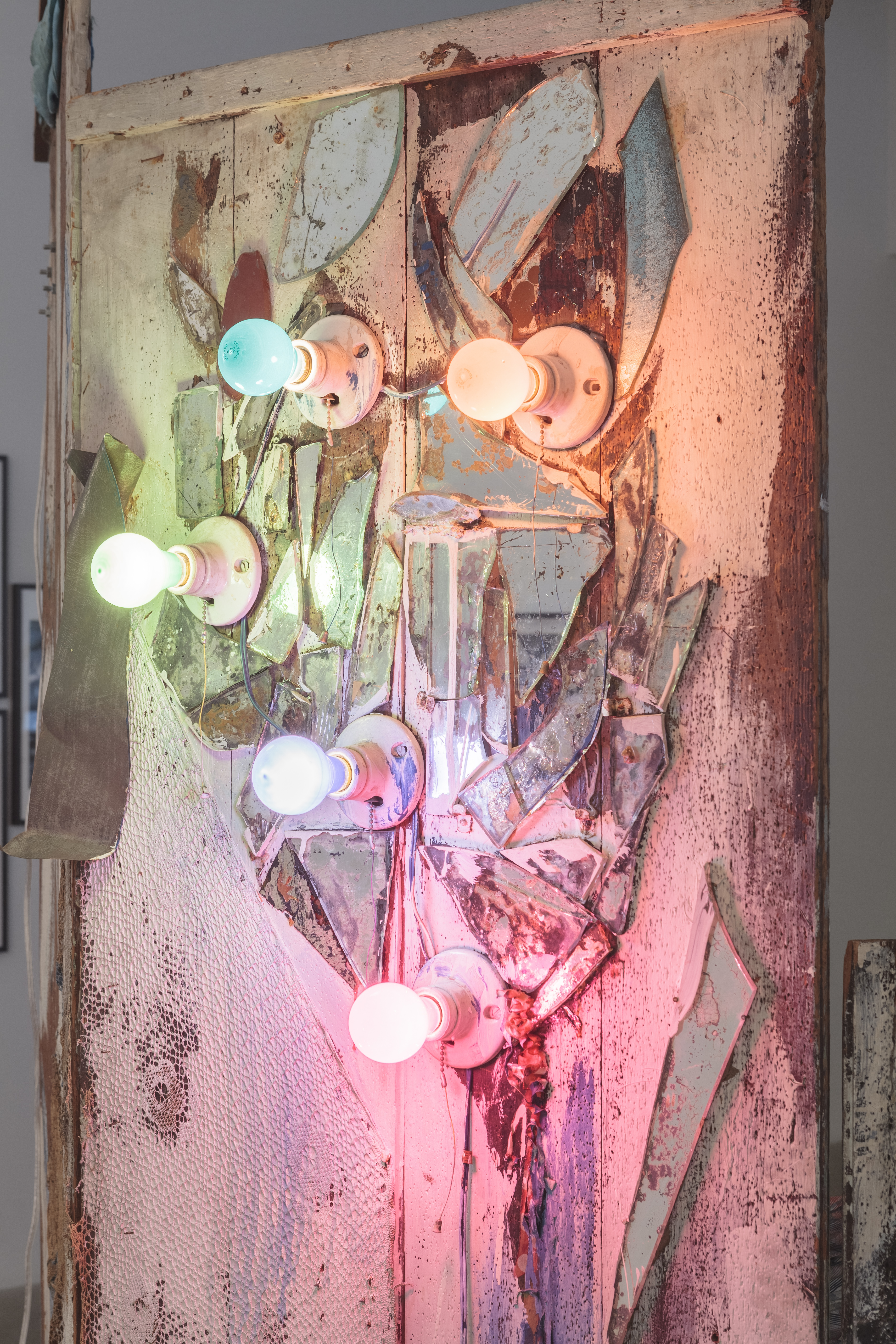 close up image of part of the work: lightbulbs of different colors and shattered glass