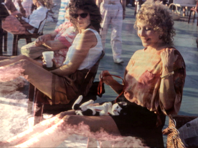 two women sit side by side, a white cloud is covering part of their legs