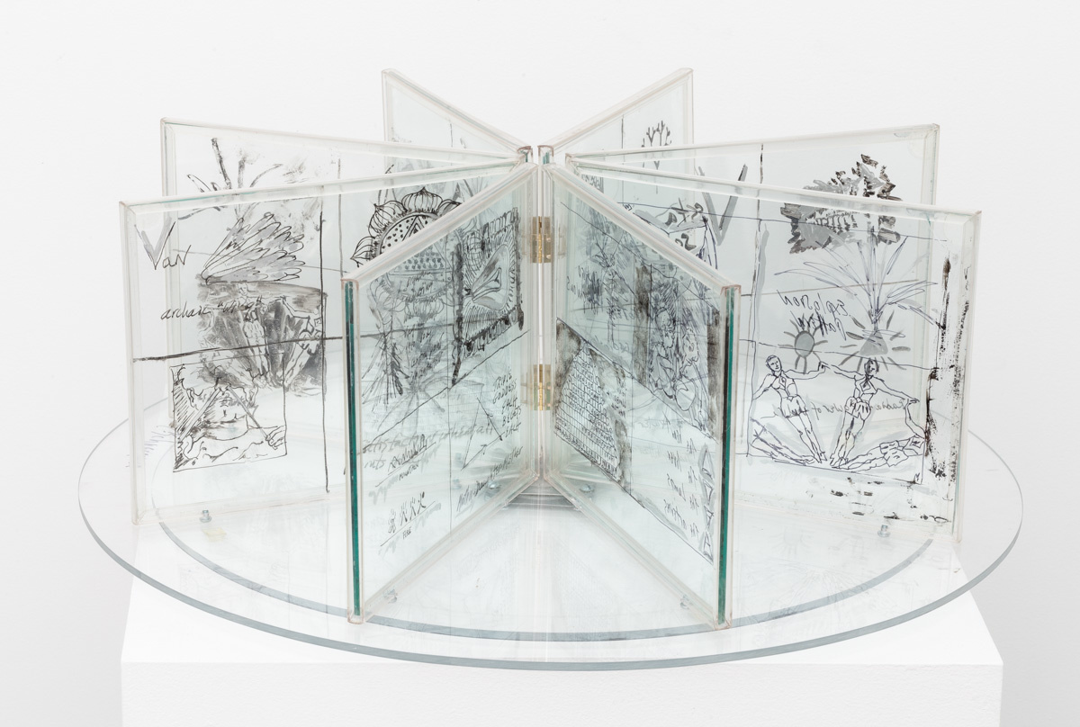 8 plexiglass panels arranged in a circle, each divided into four quadrants with various line drawings of subjects such as fruit and people.